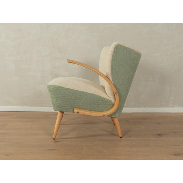 A wonderful two-tone armchair from the 1950s. Its high-quality beech frame is reupholstered with the original spring core...