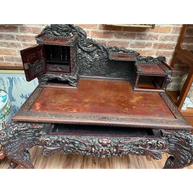 Bold dragon carving gives this wooden writing desk a striking presence. A sweeping dragon crest rises above swirling...