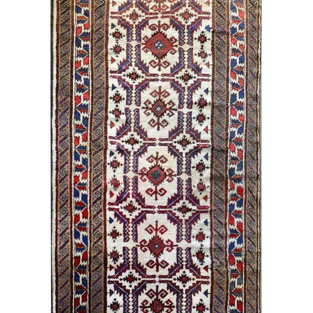 A beautiful vintage Persian Lori runner with a wonderful stylized floral pattern woven in crimson, indigo, and brown...