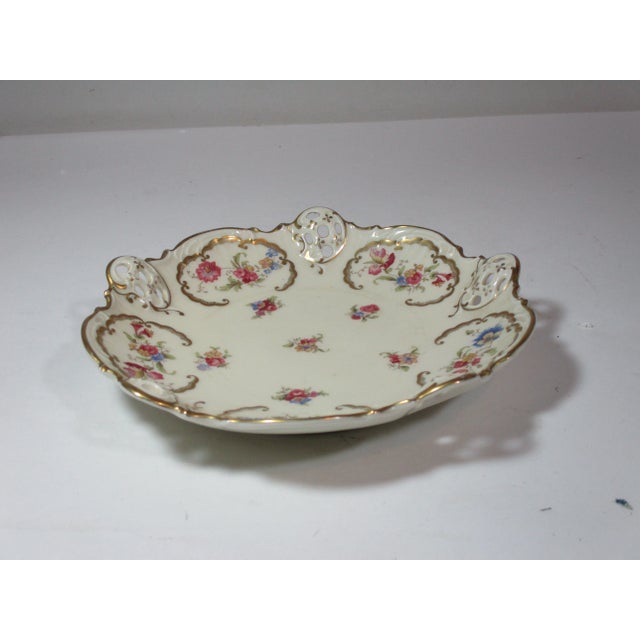 A vintage porcelain serving bowl made by the Rosenthal Co., in Germany. The bowl has a scalloped rim with pierced...
