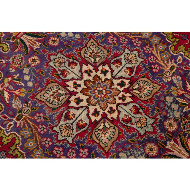 Beautiful vintage Persian Tabriz hand-knotted wool rug with a red color field. This piece has a purple frame and...