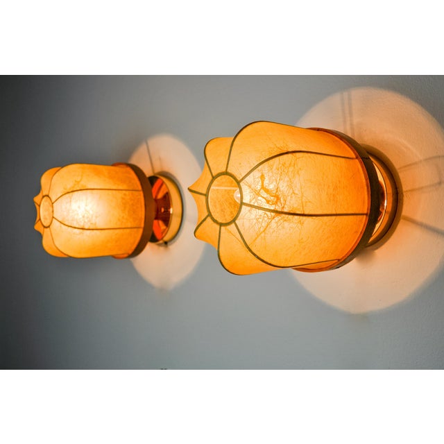 Very beautiful pair of "cocoon" wall lights designed and produced in Italy in the 1970s. Superb manual work of laying...