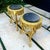 A sophisticated matching set of two French-style side tables, each featuring an ornate gold-leaf frame and a dramatic...