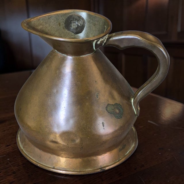 This Antique Victorian English Tavern Copper Measuring Harvest Jug is a beautifully crafted pitcher made of copper,...