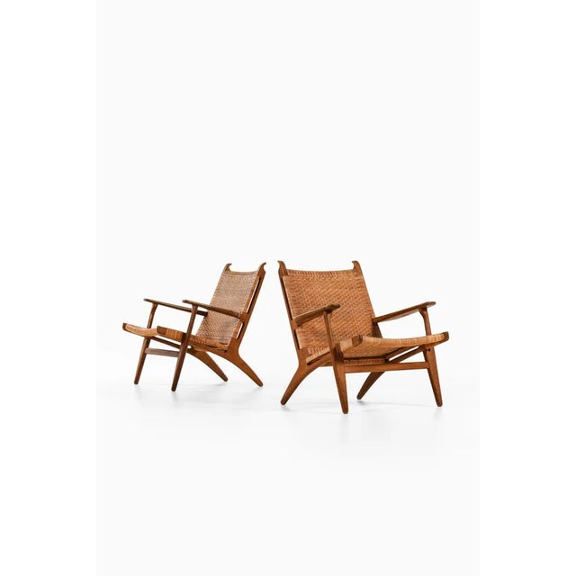 Pair of easy chairs in oak, woven cane by hans wegner, 1949 additional information: material: oak, woven cane style: mid...