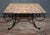 An elegant coffee table or side table, combining a wrought iron base with a marble top in natural hues. The rectangular...
