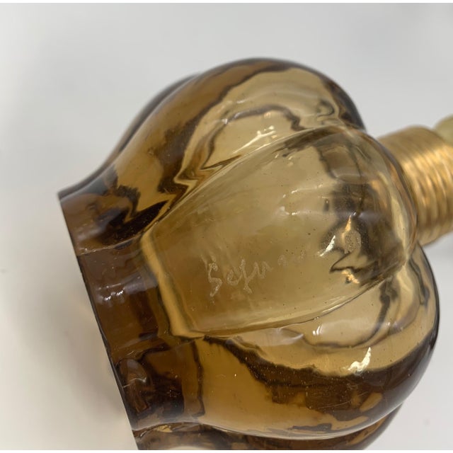 A pair of lamps composed of a smoky brown blown glass base with a polished surface by seguso; the amber transparency of...