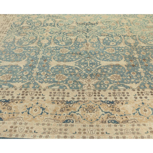 An early 20th century antique Tabriz carpet from Northwest Persia, the abrashed dark blue-green field with enlarged split-...