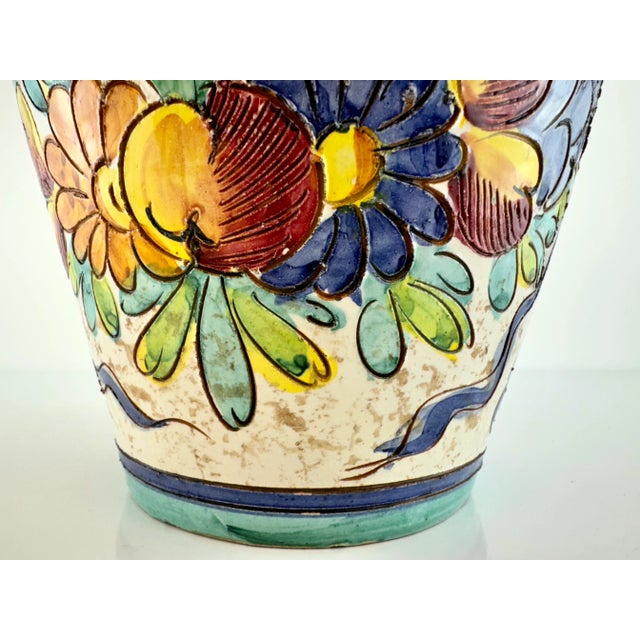 This is a beautiful vintage Italian ceramic vase featuring vibrant hand-painted floral designs. The vase is adorned with a...