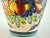This is a beautiful vintage Italian ceramic vase featuring vibrant hand-painted floral designs. The vase is adorned with a...