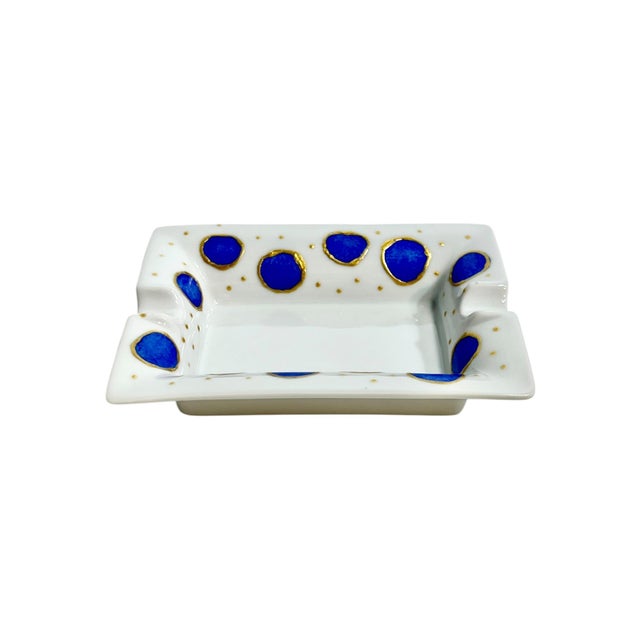 A charming vintage French ceramic ashtray or catchall featuring a crisp white ground adorned with bold cobalt blue polka...