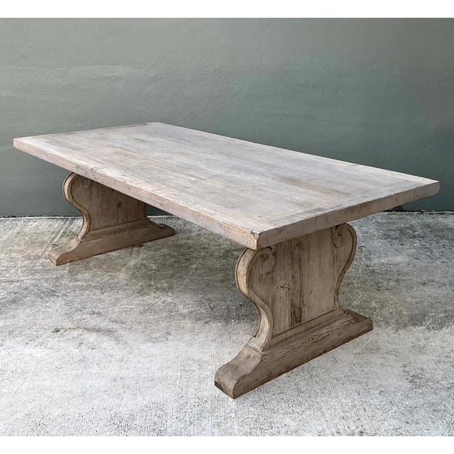This vintage dining table commands attention with its sturdy plank top and sculptural trestle base. The rectangular top is...