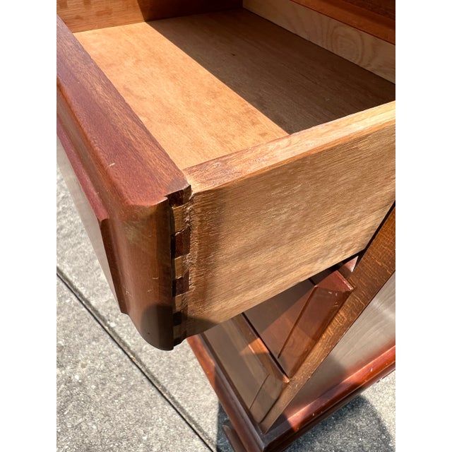 Cherry wood three drawer nightstand in a Traditional style with dovetail drawers .
