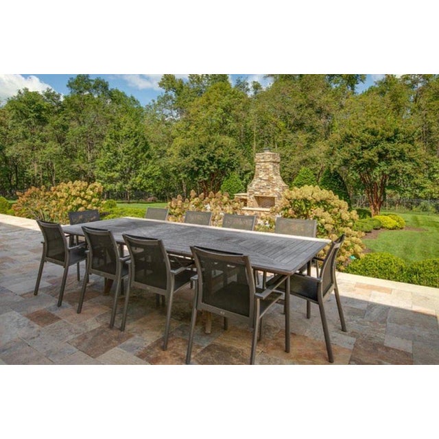 A large Gloster extendable outdoor dining table, crafted from solid teak. The tabletop features a striking geometric inlay...