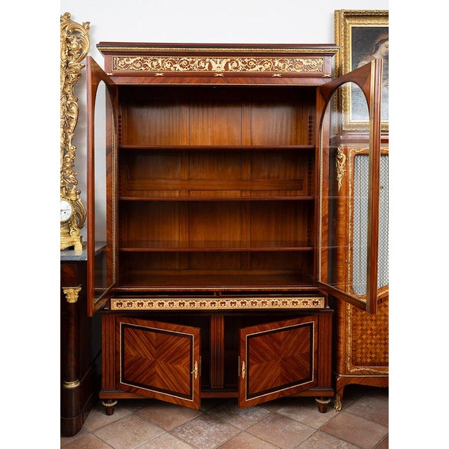Antique bookcase/sideboard in fine exotic wood with expertly chiseled gilded bronze inserts. The lower part features two...