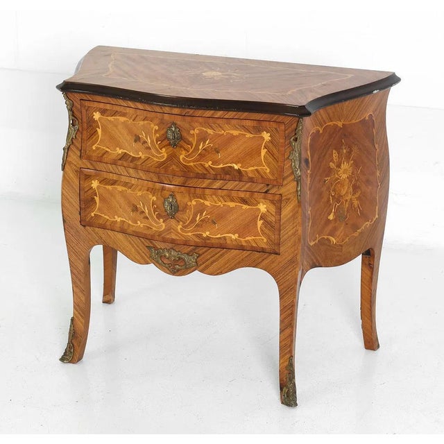 A very well made French Louis XV style 2 drawer chest. The chest exhibits masterful inlay alongside finely worked design...