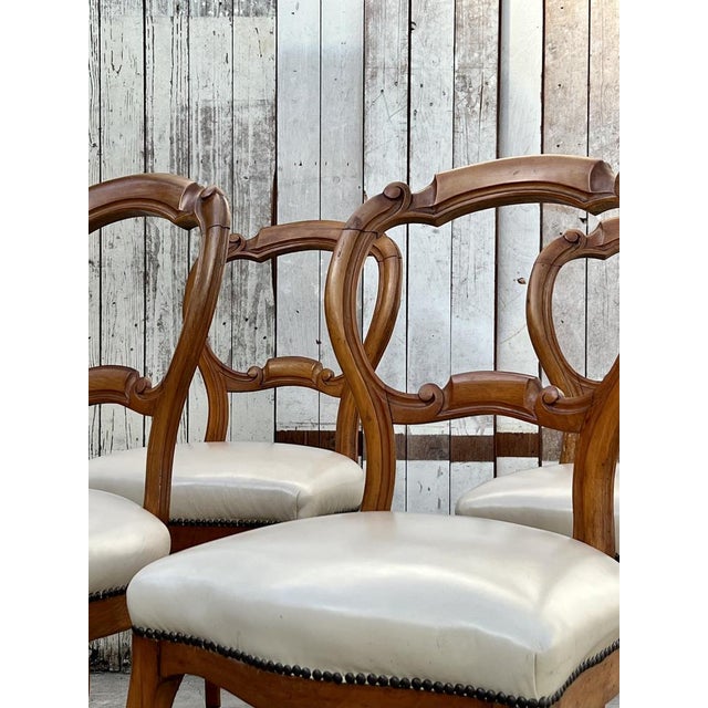 Beautiful rococo revival style, balloon back dining chairs in a set of four. The chairs have been restored with leather...