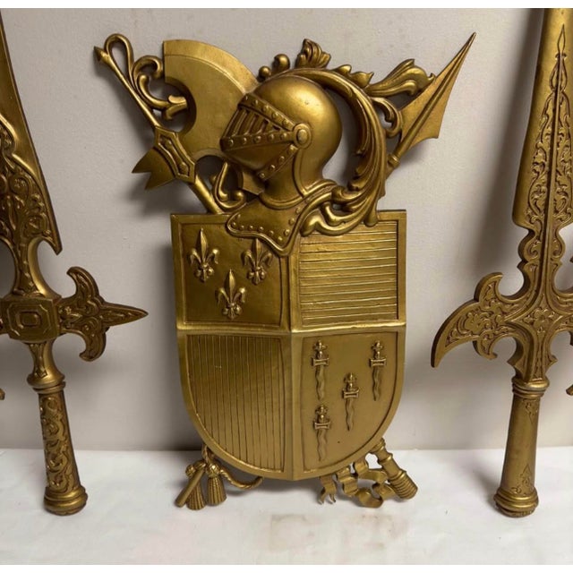 Vintage Gold 3 piece wall hanging, made by Sexton. Center 10.5”h x 13.5”W, swords 9”w x 25.5”H.
