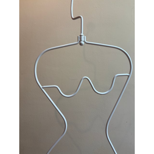 White painted steel mannequin with sculptural, feminine form. A wooden sphere at the top provides a perch for hats or...