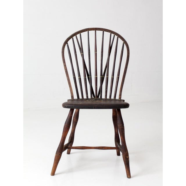Antique 19th-century brace-back Windsor chair with a tall fan back, slender spindles, diagonal braces, and bentwood crest....