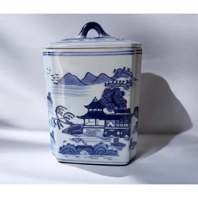 Elegant blue and white porcelain canister with classic scenic motif. Features deep blue hand-painted landscape details for...