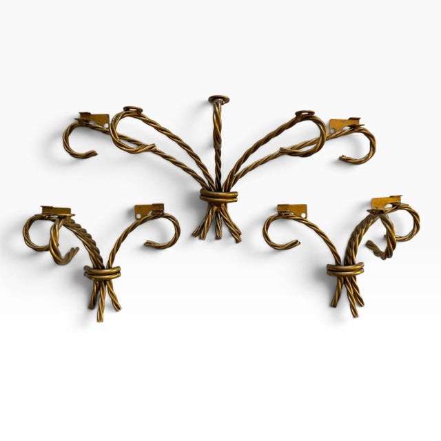 Striking vintage set of three Hollywood Regency wall shelves featuring sculptural gilt-tone metal ropework and clear glass...