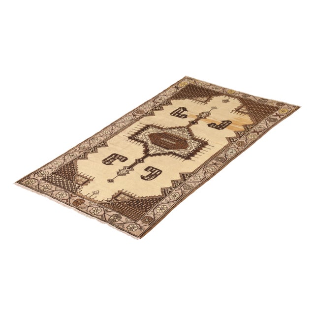 Hand-knotted in wool originating from Turkey circa 1950-1960, this vintage Oushak rug connotes a distinguished mid-century...