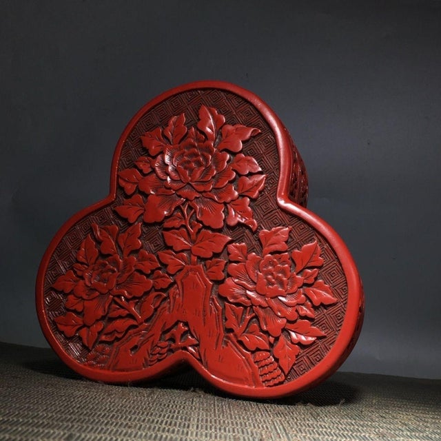 Add a touch of dramatic Chinoiserie elegance to your space with this exquisite Vintage Cinnabar Carved Lacquer Box. Shaped...