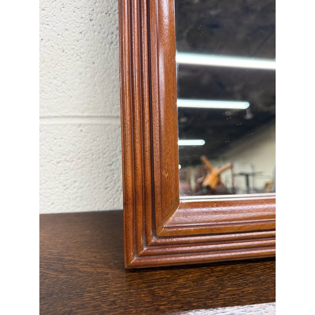 This is an elegant vintage traditional wall mirror featuring a richly toned cherry finish with stepped molded frame...