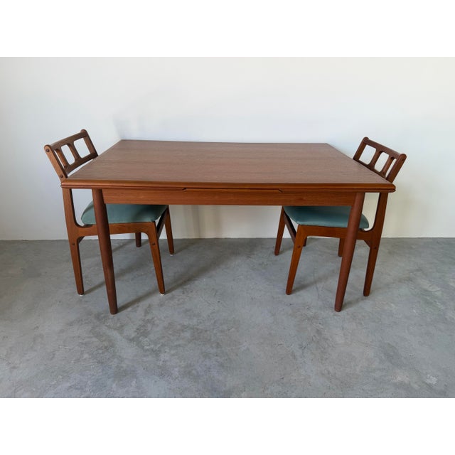 Elegant 1960s Danish Modern extending dining table crafted in richly grained teak by AM Ansager Møbler, Denmark. This...