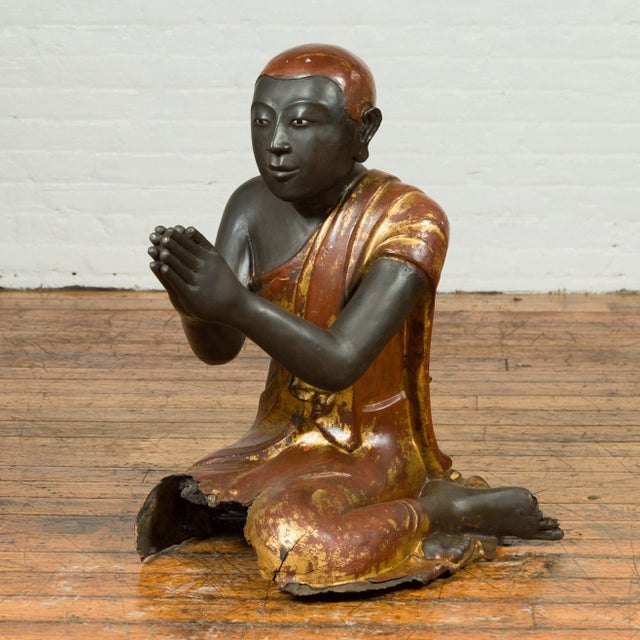 A Thai kneeling ceremonial monk sculpture from the 19th century with hand painted gilt and lacquer over stone. Found in a...