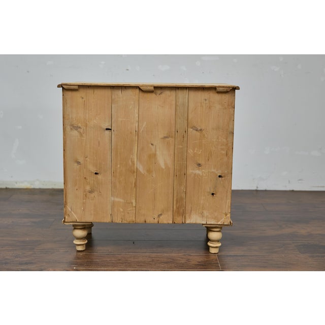 An English pine four-drawer chest from the 19th century with natural finish, turned feet and rustic character. This...