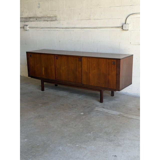 This exceptional low credenza showcases striking symmetrical grain patterns across its entire front profile. Elegant...
