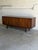 This exceptional low credenza showcases striking symmetrical grain patterns across its entire front profile. Elegant...