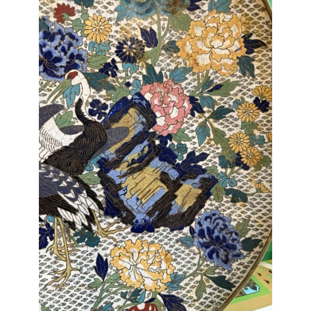 A superb and richly decorated Meiji period Japanese cloisonne enamel charger featuring an elaborate scene of two red-...