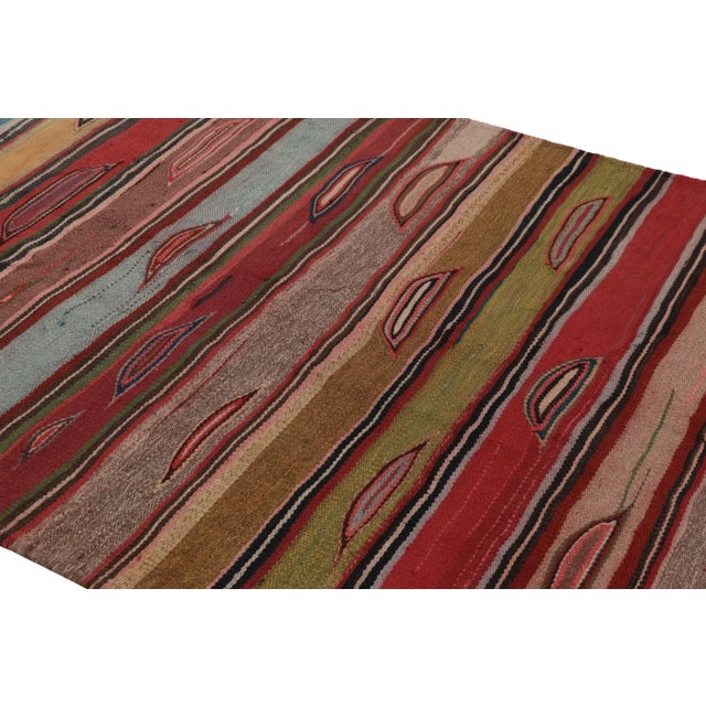 Made with handwoven wool in Persia 1950-1960, this 5x8 vintage Heriz Kilim is a particularly bright and sought-after work...