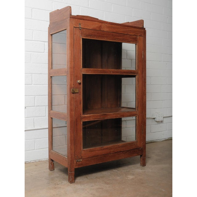 This handsome wooden glass-front cabinet showcases the warmth and authenticity of 20th-century Indian craftsmanship. Built...
