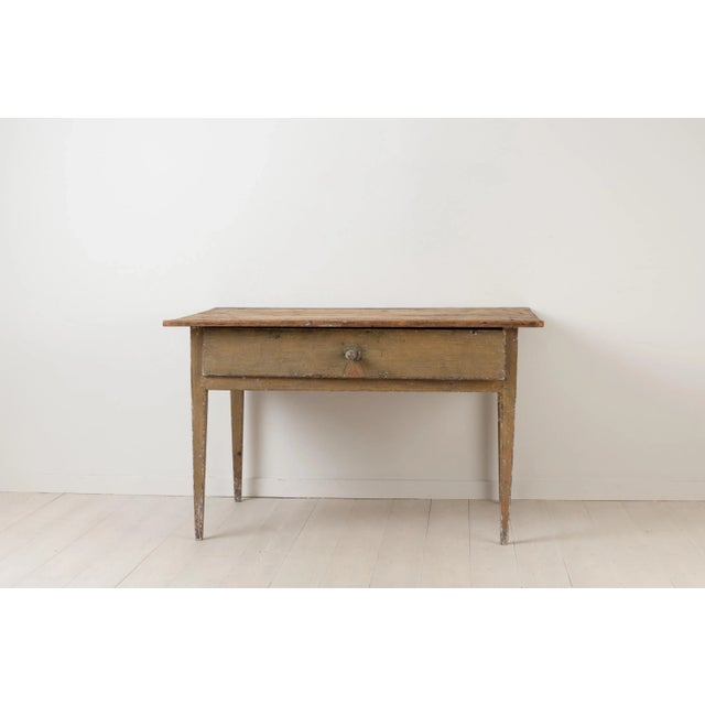 Primitive neoclassical table in Folk Art. The table is provincial and made from painted pine. It has one single large...