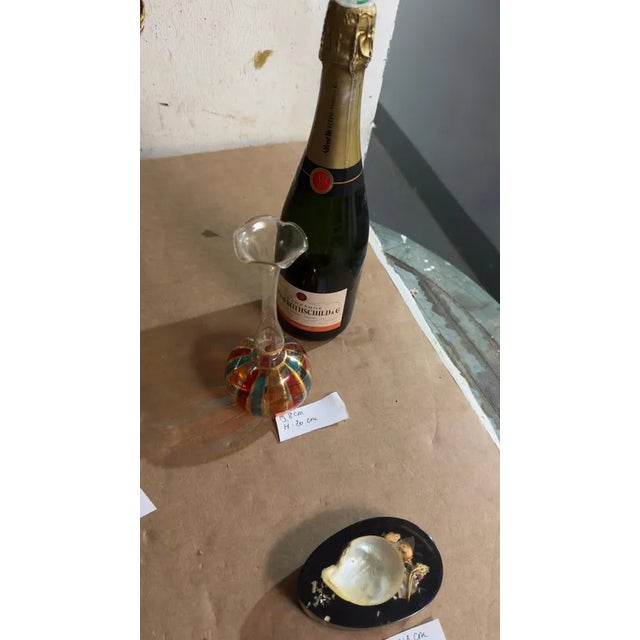 This vase is a perfume bottle, that can be used with the cap, as it, or as a vase if we put off the cap. The painting is...