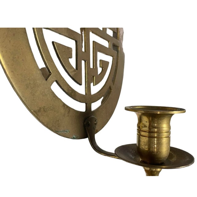 A stunning pair of round vintage Chinoiserie brass wall sconce candleholders.