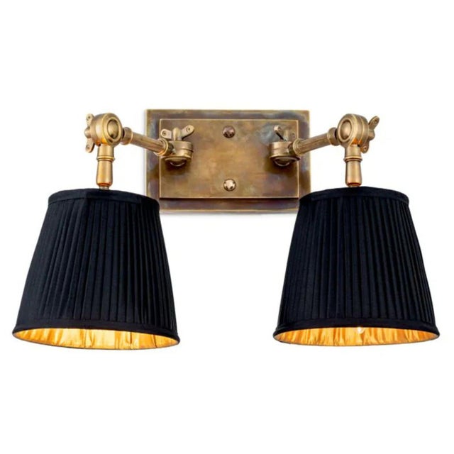 This contemporary vintage brass metal double wall lamp is a decorative wall light with two adjustable arms and black...