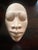 Handcrafted ceramic mask by Jamaican artist Gene Pearson, featuring serene minimalist facial details and a natural clay...