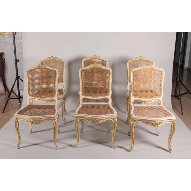 A set of Six French 19th century Ivory painted and parcel-gilt Chairs with Caned Seats.
