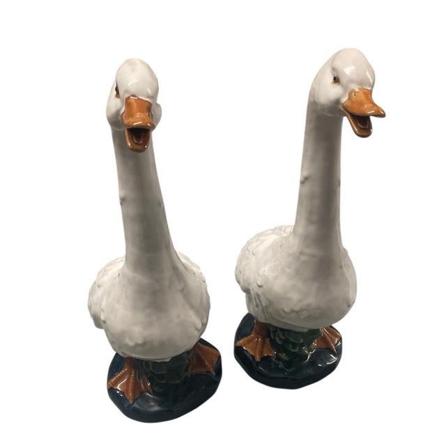 A pair of vintage ceramic geese. Crafted with elegant, elongated necks and expressive open beaks, these figurines capture...
