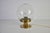 This mid-century brass and glass table lamp was produced in germany in the 1960s and features a refined, minimalist design...