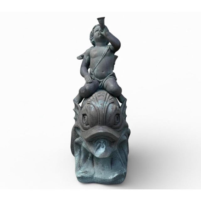 Monumental bronze fountain depicting a classically rendered cherub (putto) riding a stylized dolphin, sourced from a Star...