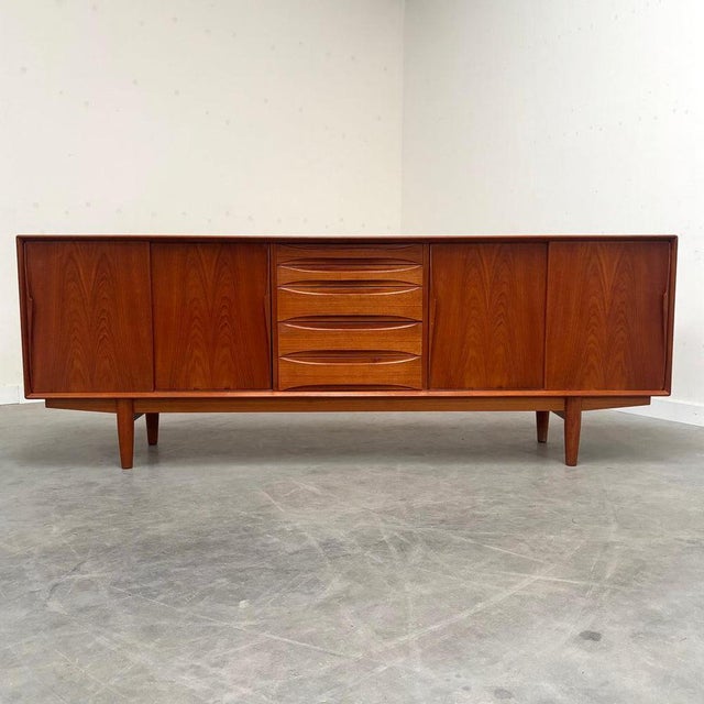 Remarks: Skovby sideboard designed by Arne Vodder, Denmark 1960s. Teak veneer with four slide doors and five drawers....