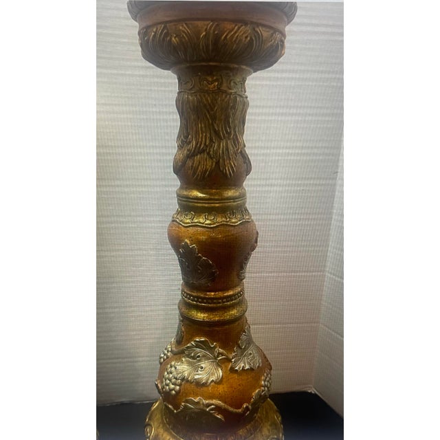 Ornate pair of Old World-style pillar candle holders featuring dimensional grape clusters, scrolling vines, and leaf...