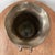 The Vintage Penco Brass Vase features a unique design with fluted sides, a scalloped top, and a decorative rope tie. Made...
