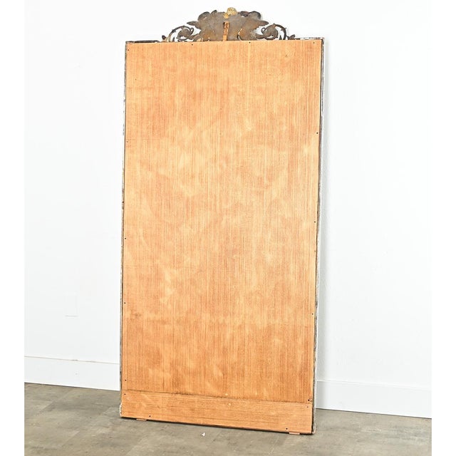 An impressive Louis Philippe gold gilt mirror with signature arched corners at the top, crested with an ornate floral...
